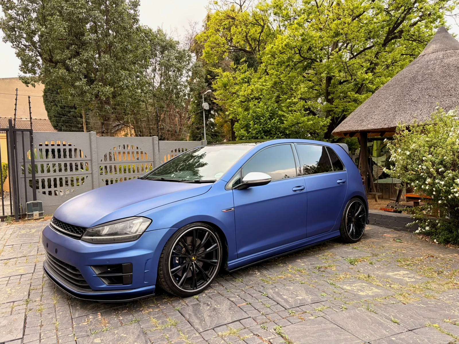 Matte blue Volkswagen Golf photographed from the front three-quarter angle