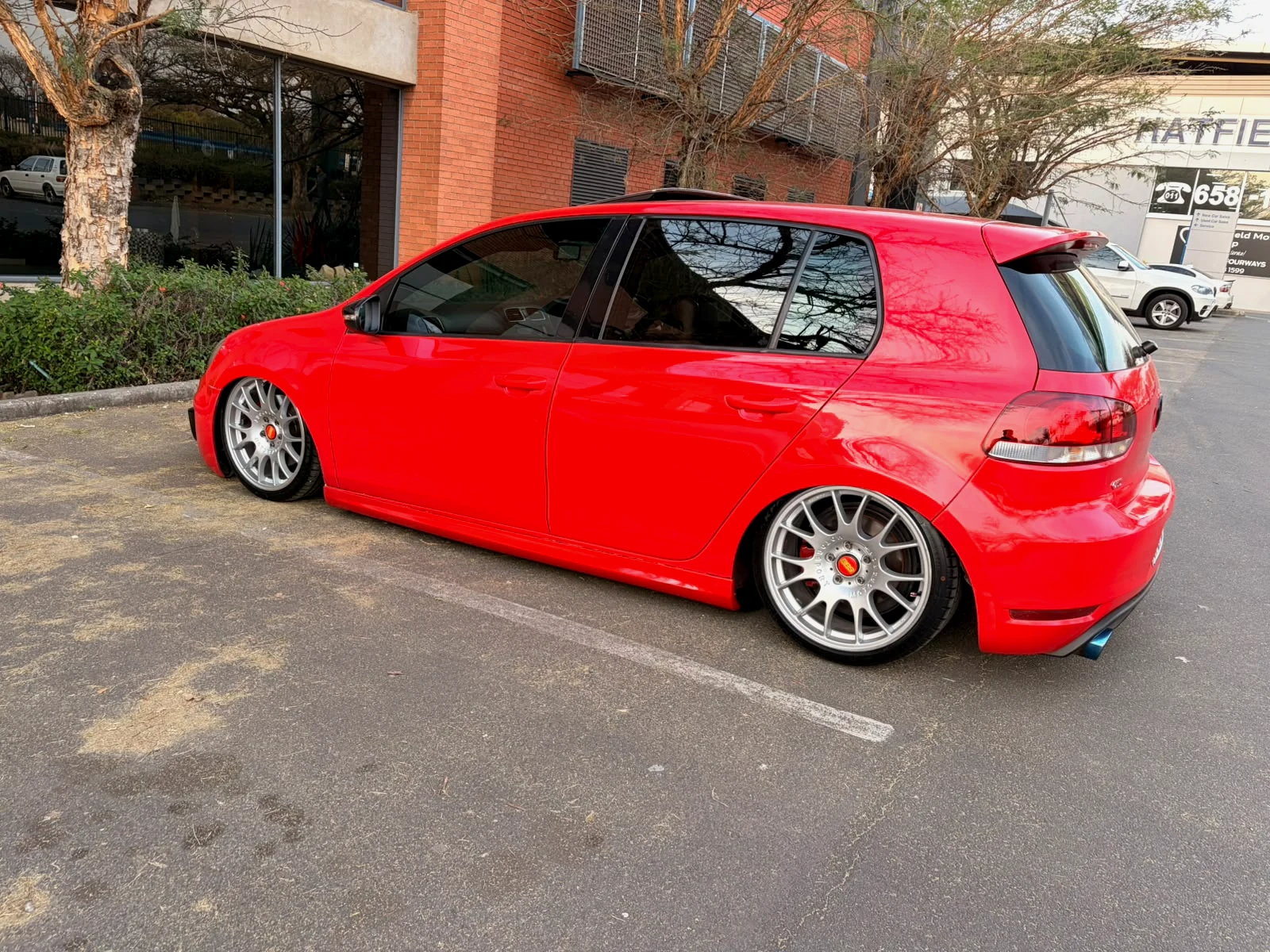 Modified red Volkswagen Golf in side profile